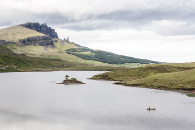 Scenic view of lake by mountain against sky