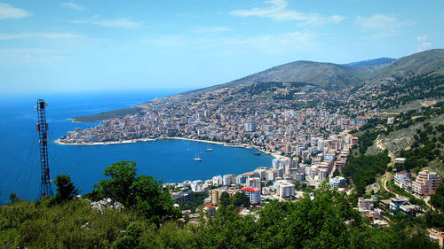 High angle view of city by sea against sky