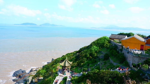 Scenic view of sea by buildings against sky