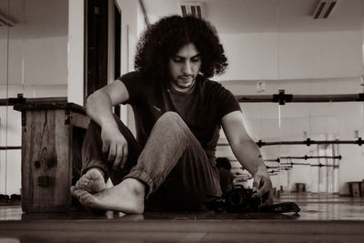 Full length of young man sitting at home