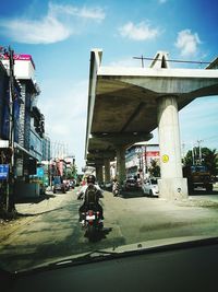 Cars on road in city against sky