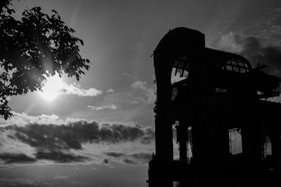 Low angle view of silhouette built structure against sky