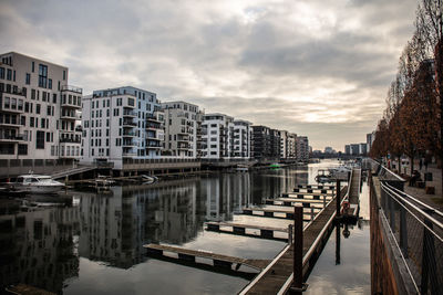 Canal amidst buildings in city against sky