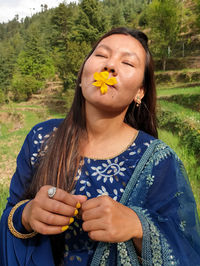 Portrait of young woman holding plant