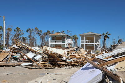 Abandoned wood against houses and clear blue sky