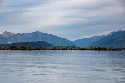 Scenic view of lake by mountains against sky