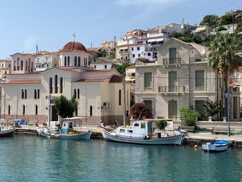 Sailboats moored on canal by buildings in city