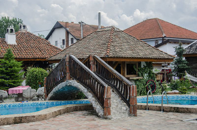 Houses by swimming pool against sky