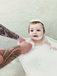 Cropped hands of mother bathing daughter in bathroom