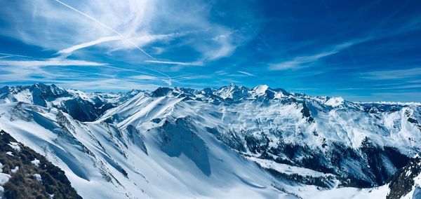 Scenic view of snowcapped mountains against blue sky