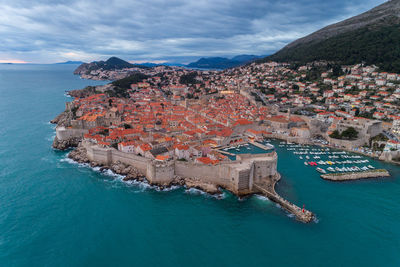 High angle view of townscape by sea against sky