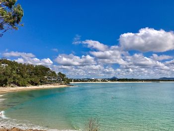 Idyllic view of beach against blue sky
