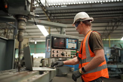 Rear view of man standing in factory