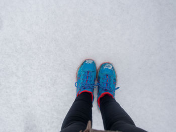 Low section of woman standing on snow