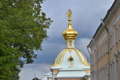 Low angle view of statue by building against sky