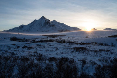 Scenic view of snowcapped mountains against sky during sunset