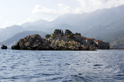 Scenic view of sea and mountains against sky