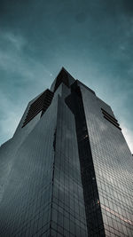 Low angle view of modern building against cloudy sky