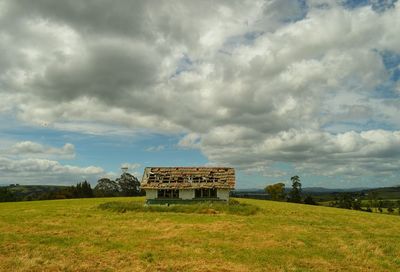 Scenic view of grassy field against cloudy sky