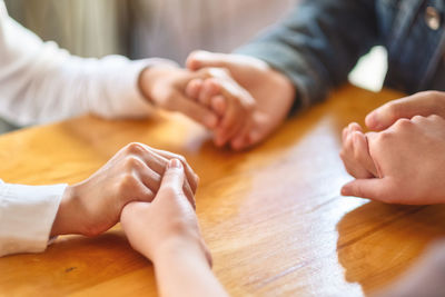 People holding hands on table