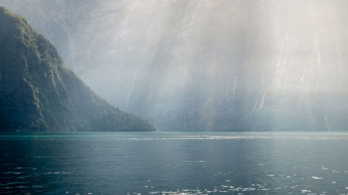 Sun rays hitting the depths of fjord. milford sound, fiordland national park, new zealand