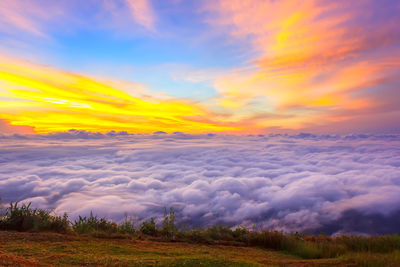 Scenic view of dramatic sky over land during sunset