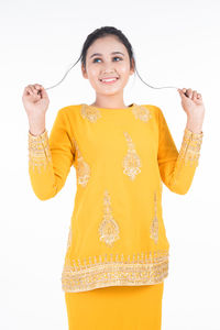 Portrait of a smiling young woman against white background