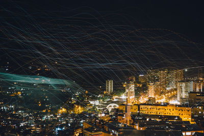 Illuminated cityscape against sky at night