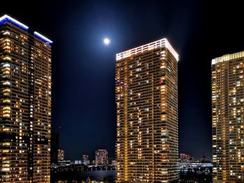 Low angle view of illuminated buildings against sky at night