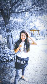 Portrait of smiling young woman standing in snow