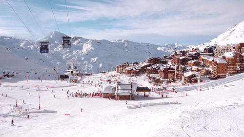 Buildings on snowcapped mountains against sky