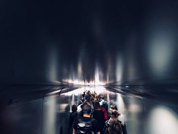 Group of people standing on illuminated road at night