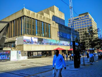 People walking on street against buildings in city