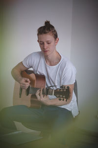 Focused young singer while singing and playing guitar in an afternoon idyll. a common portrait 