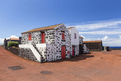 Exterior of building by sea against blue sky