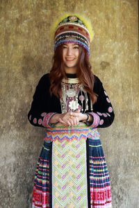 Portrait of smiling girl standing against wall