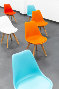 High angle view of empty chairs on table against wall