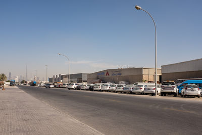 Cars on road against clear sky in city