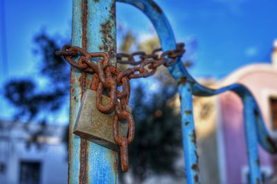 Close-up of rusty chain hanging on metal gate