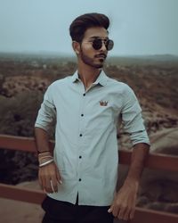 Portrait of young man wearing sunglasses standing outdoors