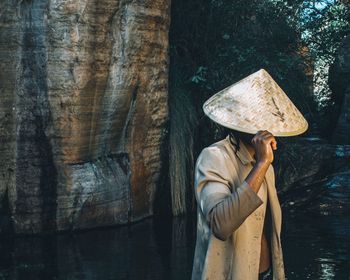 Midsection of woman standing by tree