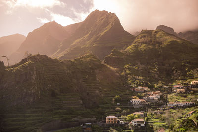 Aerial view of townscape by mountain against sky