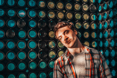 Portrait of young man standing against wall