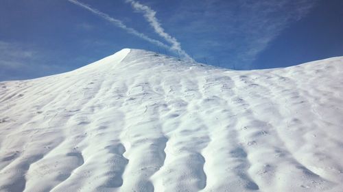 Low angle view of snow covered mountain against sky