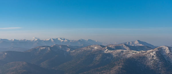 Panoramic view of mountain range against blue sky