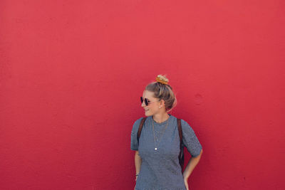 Boy standing against red wall