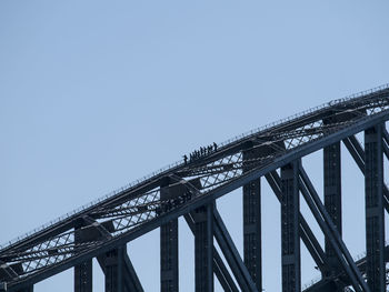 Silhouette people at sydney harbor bridge against clear sky