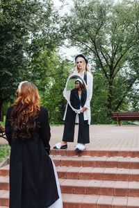 Full length of woman standing against plants