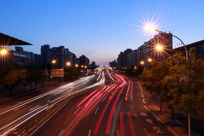 Light trails on road against sky at night