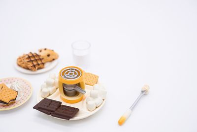 High angle view of cookies in plate against white background